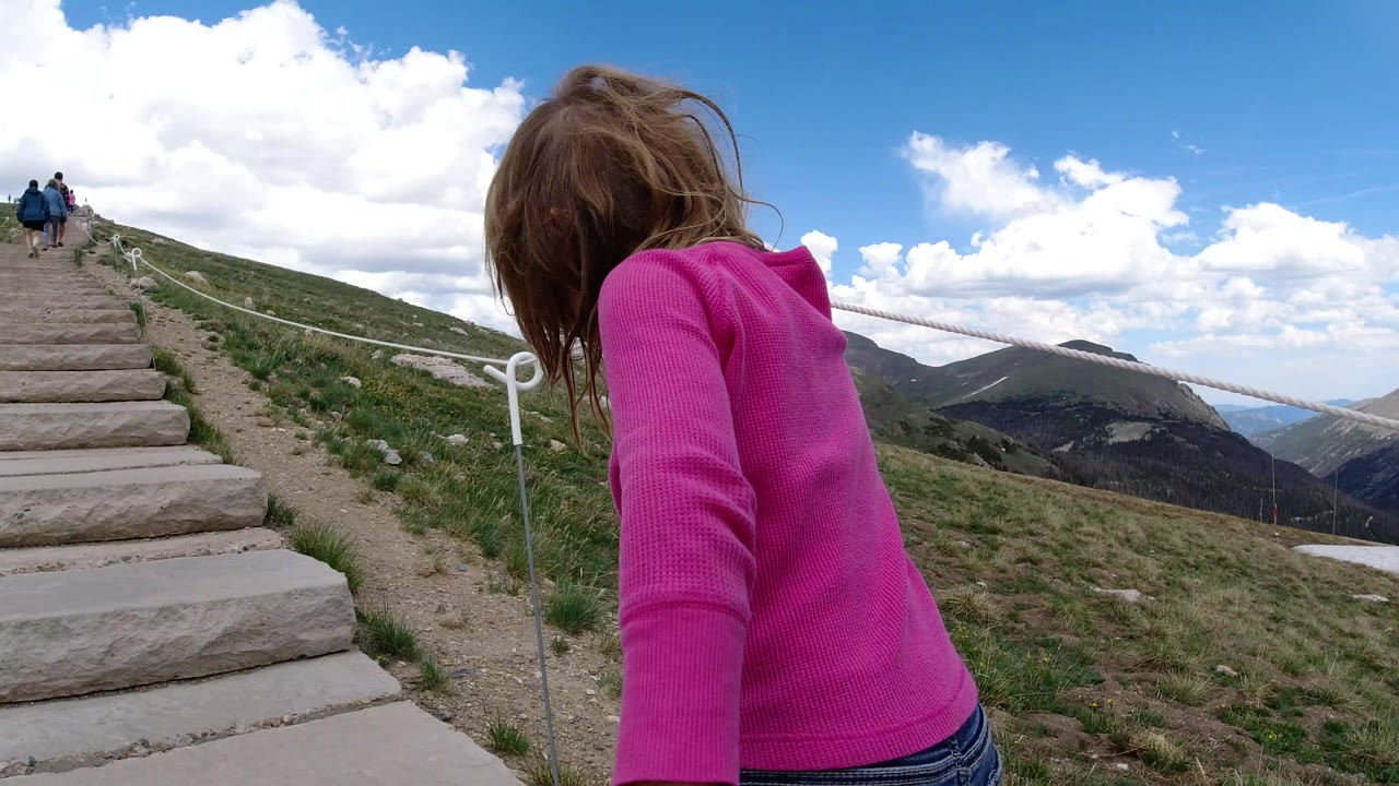 Young girl in a pink top beside mountain steps
