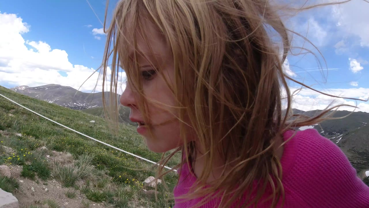 Close view of a child in pink beside a mountain trail