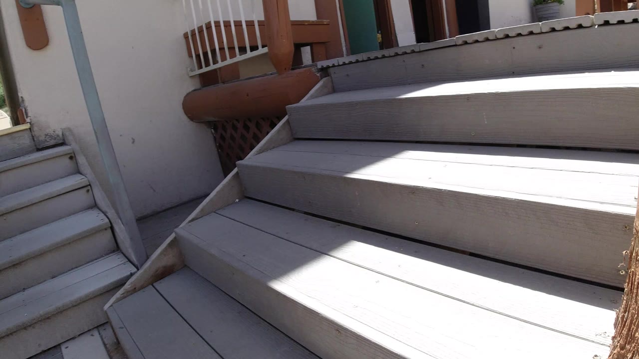 Gray outdoor stairs beside a building in bright sun.