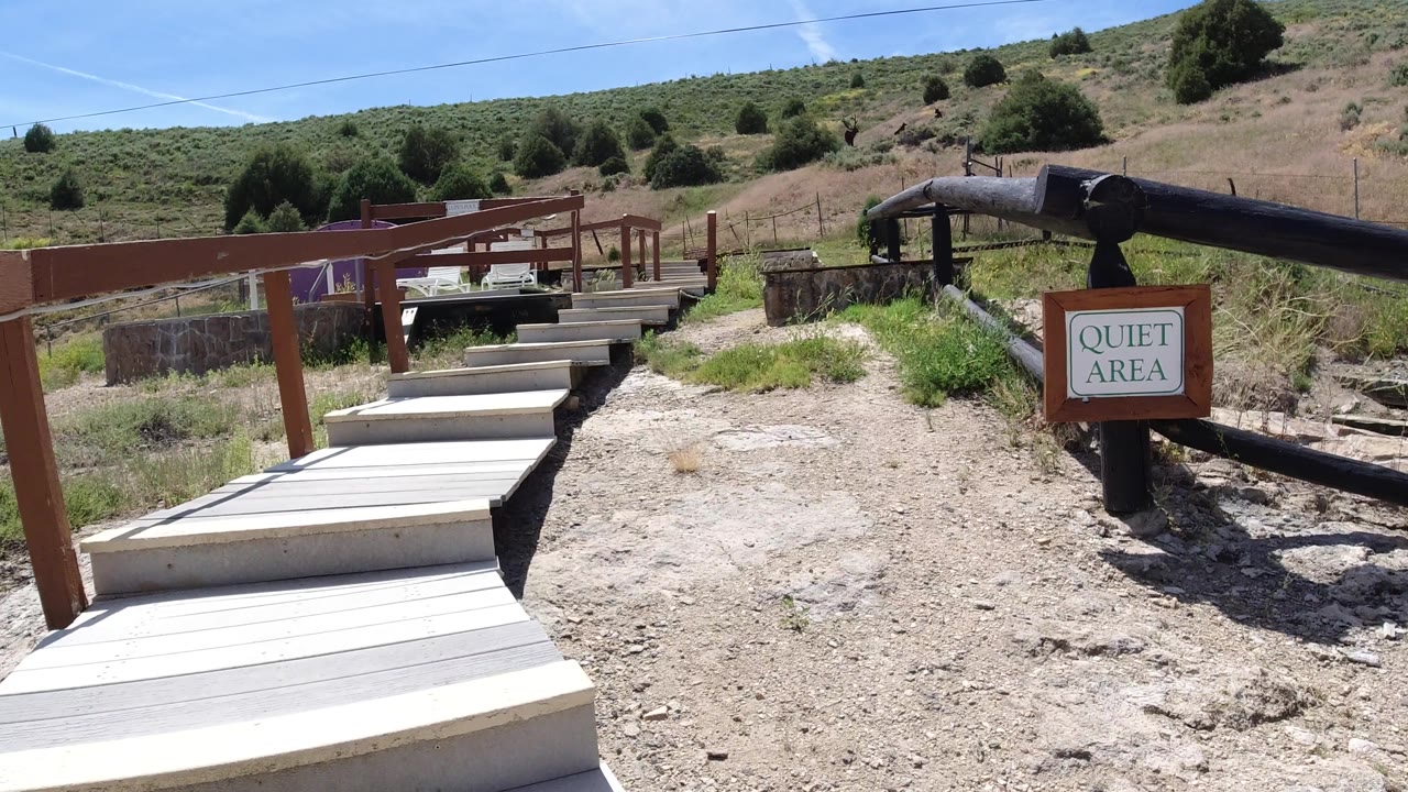 Caution sign and quiet area sign beside a boardwalk and railings.