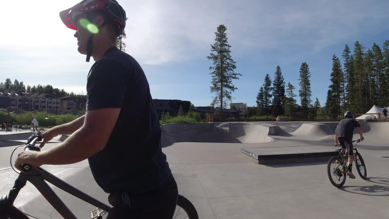 Close cyclist in helmet beside a concrete freestyle track.