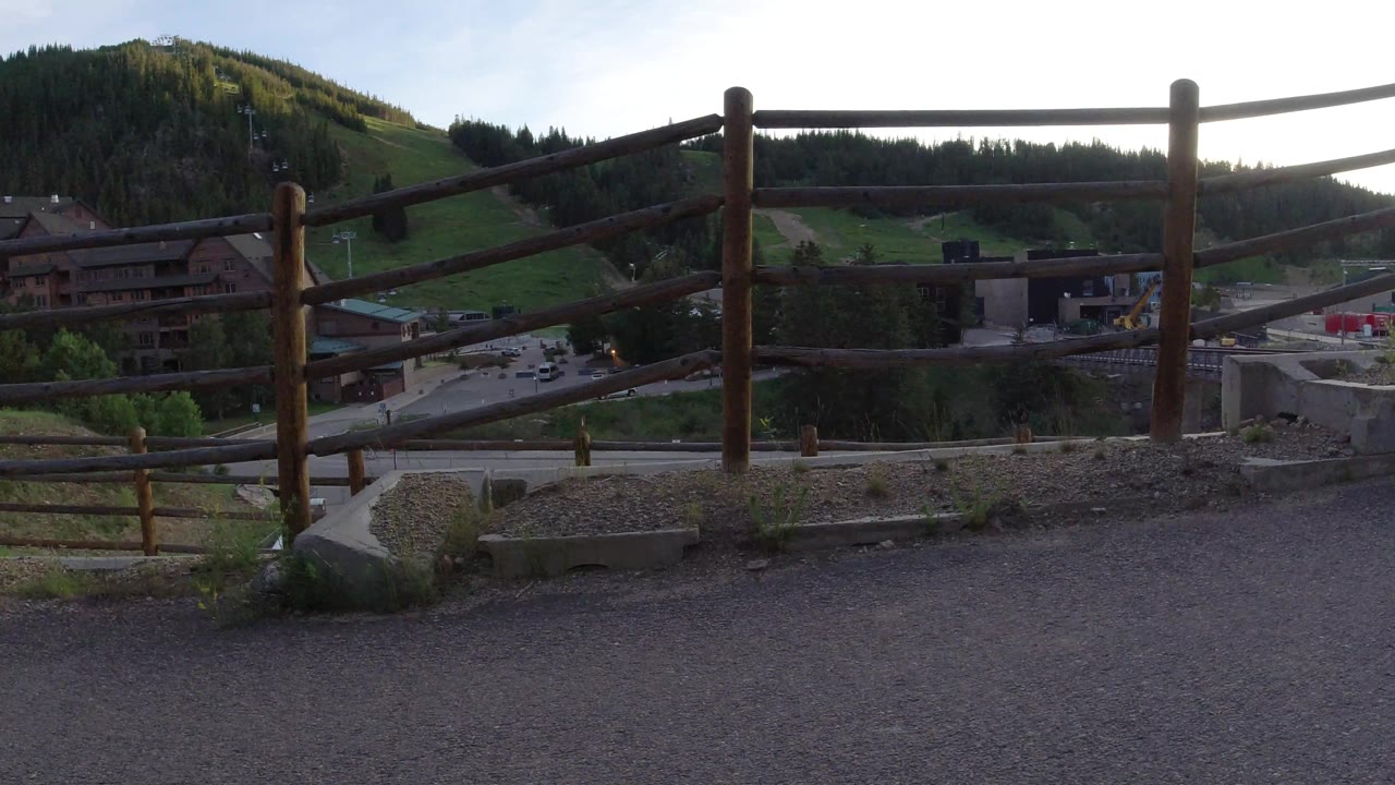 Rustic railing across a mountain-town overlook.