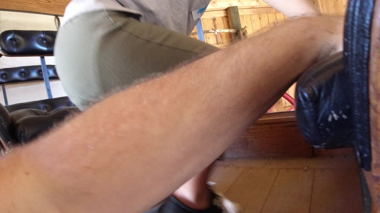 At 0:01 in Winter Park, Colorado, the frame remains close on a person's leg and forearm with black bench cushions and wood trim behind them.