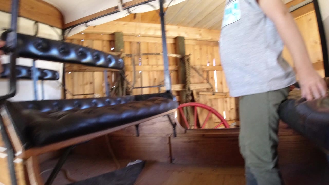 At 0:00 in Winter Park, Colorado, black tufted bench seats fill the frame while a person in a gray shirt and green pants is partly cropped at the right edge.