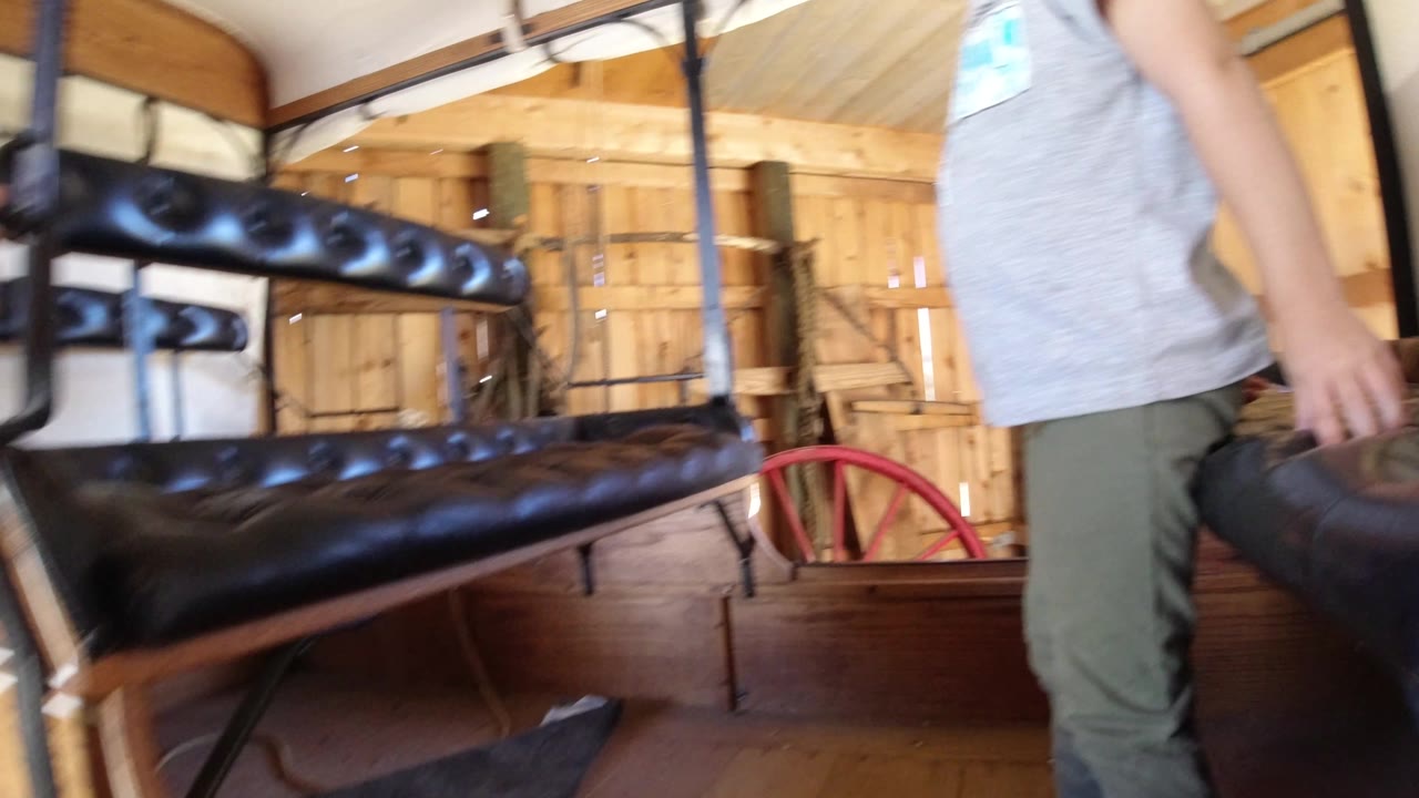 At 0:01, the person stands close to the black bench seats in the Winter Park interior, with warm wood walls and a red wheel visible behind the seating.