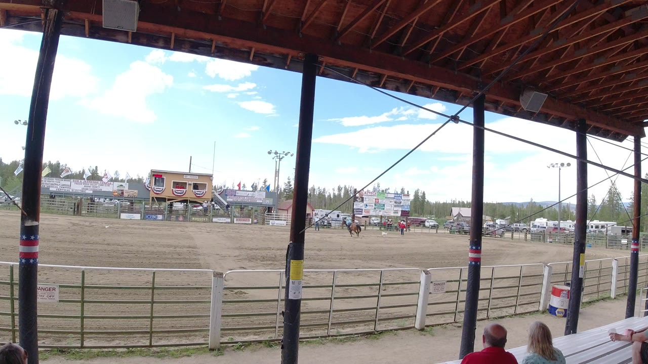 Wide view of a rodeo arena from covered stands.