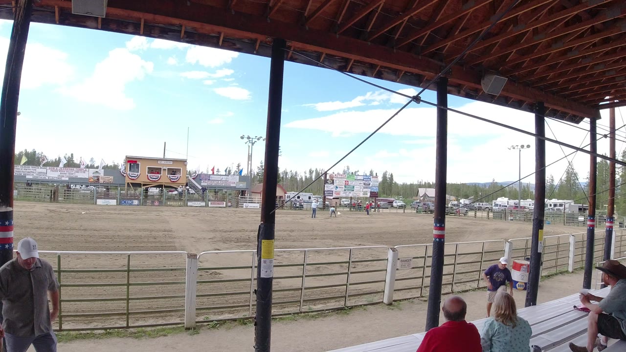 Covered bleachers overlooking a dirt arena with seated spectators.