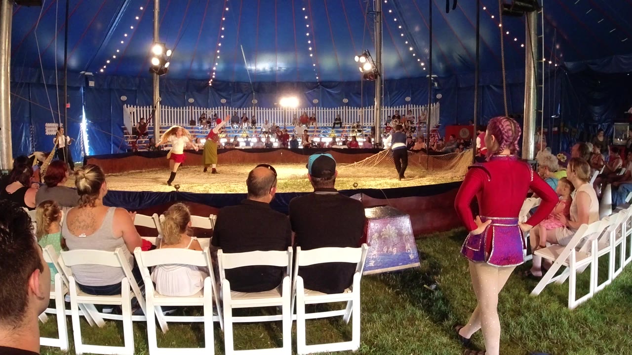 In Broomfield, Colorado, performers stand farther apart across the sawdust ring while the audience remains seated in white chairs beneath the blue tent canopy.