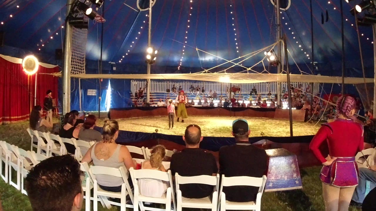 Audience members sit close to the ring in the Broomfield big top as the young acrobat duo remains centered beneath bright tent lights.