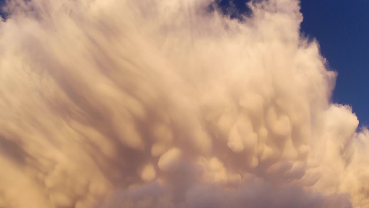 Warm cloud bank crossing a deep blue sky