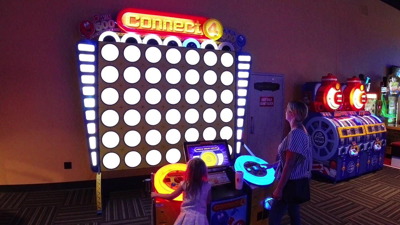Child and woman at a large Connect Four arcade game