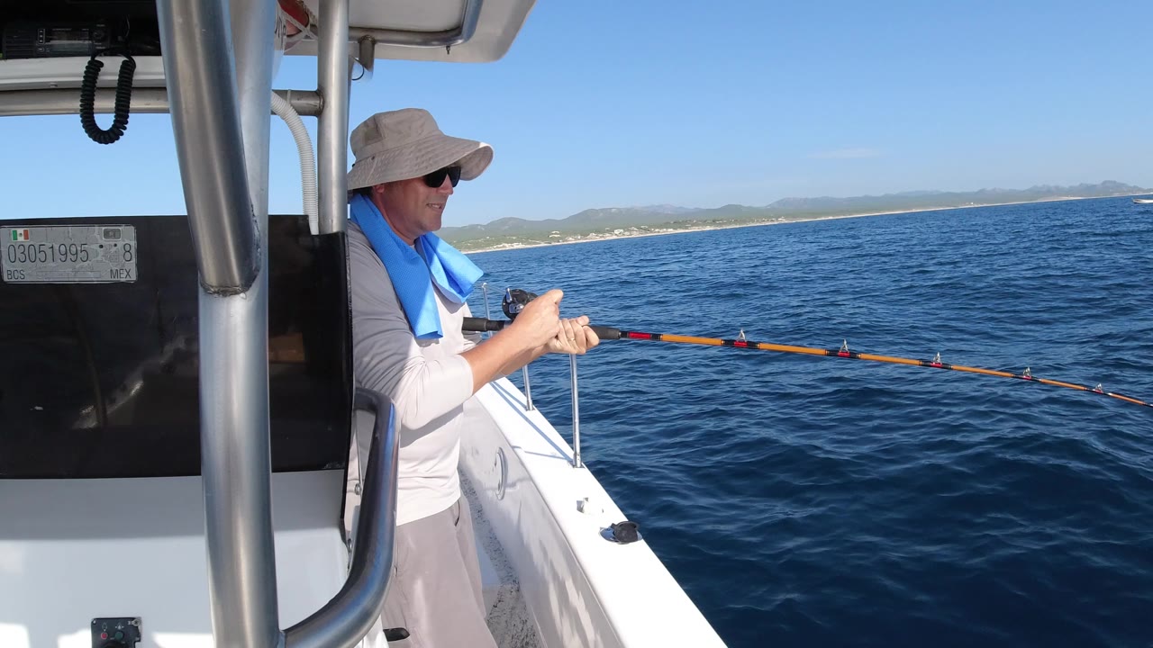 Person fishing from a small boat beside open ocean
