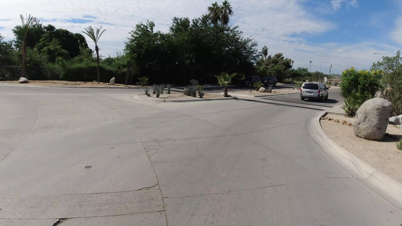 Paved road junction with desert landscaping and cars