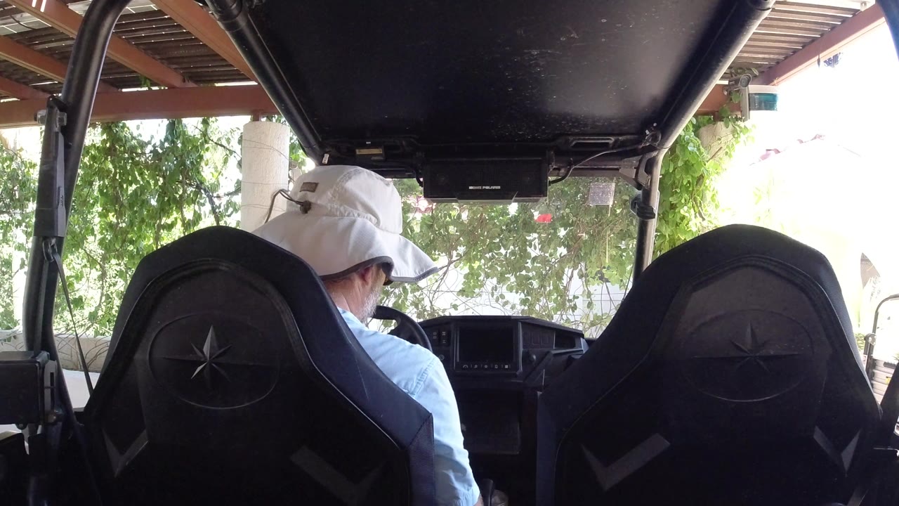 Driver seen from behind inside an ATV or off-road vehicle.