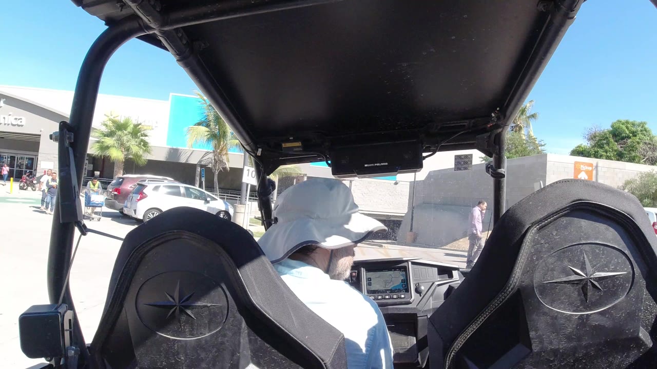 Forward view from an open vehicle facing a Walmart parking lot.