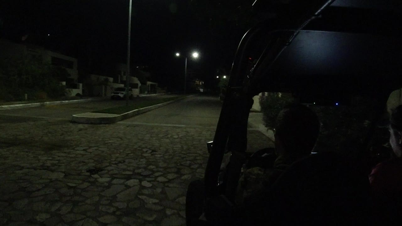 Dark vehicle interior looking toward a lit road at night
