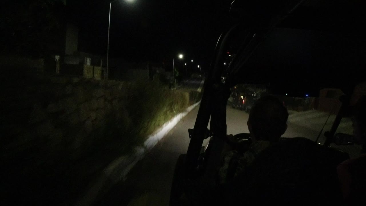 Dark road seen from inside a moving open vehicle at night