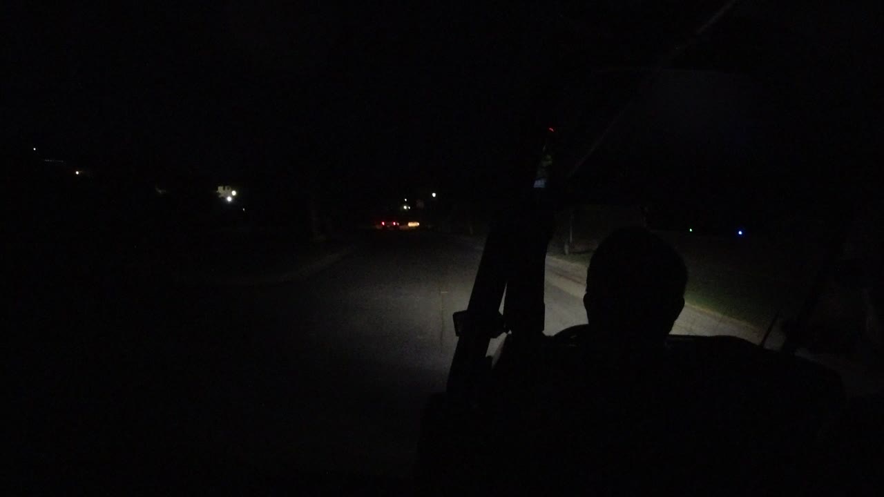 At the start of the Los Cabos, Mexico clip, a dark silhouette sits in a golf cart while headlights reveal a paved path and faint distant lights ahead.