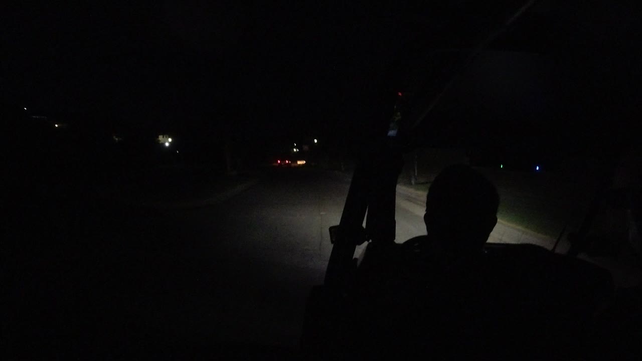 One second into the Los Cabos, Mexico footage, the silhouetted rider remains near the center as the golf cart headlights brighten the road surface ahead.