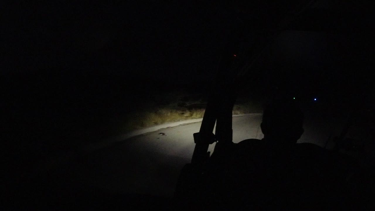Dark vehicle interior facing a headlit road at night