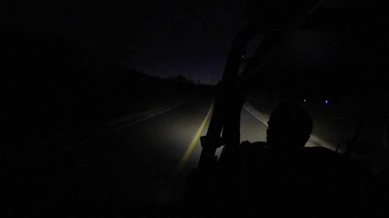 At 0:01 in Los Cabos, Mexico, the vehicle view centers on the illuminated lane markings with the occupant silhouette lower in the frame.