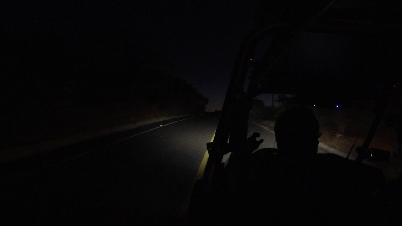 At the start of the Los Cabos, Mexico clip, a silhouetted RZR driver faces a dark road lit by the vehicle headlights.
