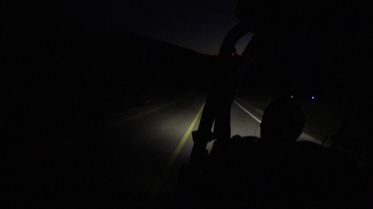 At 0:00, a dark vehicle interior frames a headlight-lit road in Los Cabos, Mexico, with a silhouetted occupant shape and no recognizable person visible.