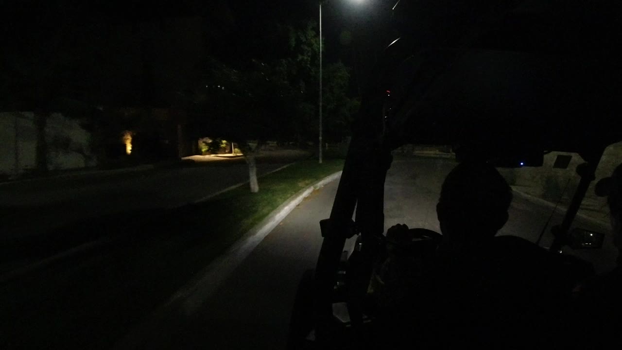 Dark vehicle interior looking down a road at night
