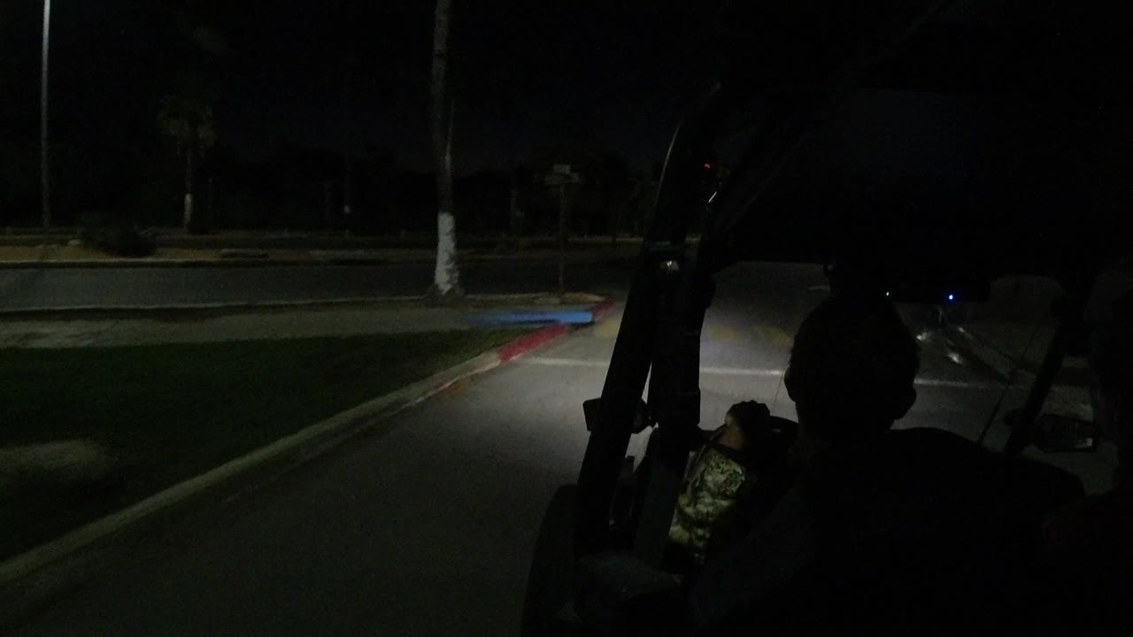 Dark vehicle view of a road with a driver silhouette at night