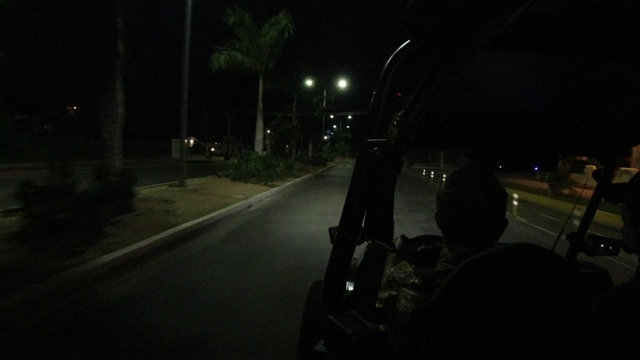 Dark road seen from inside an open vehicle at night
