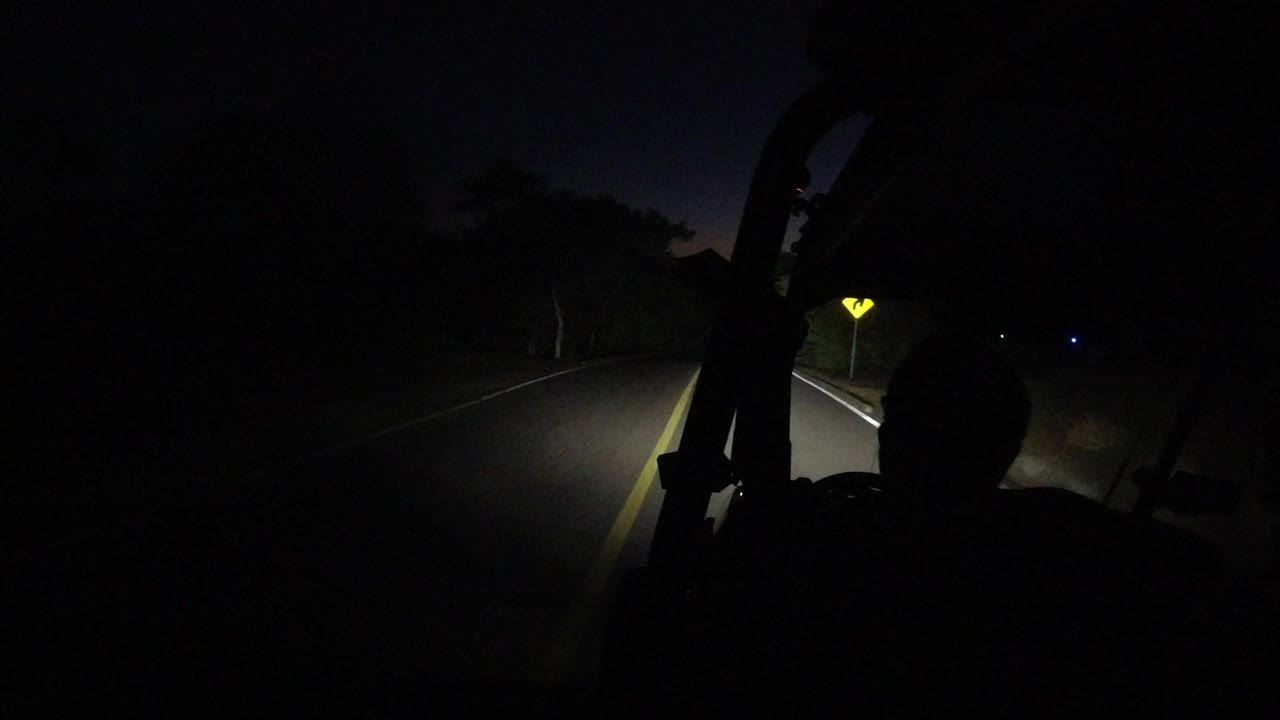 At 0:00 in Los Cabos, Mexico, a dark road appears ahead under headlights while a silhouetted rider sits in the foreground.