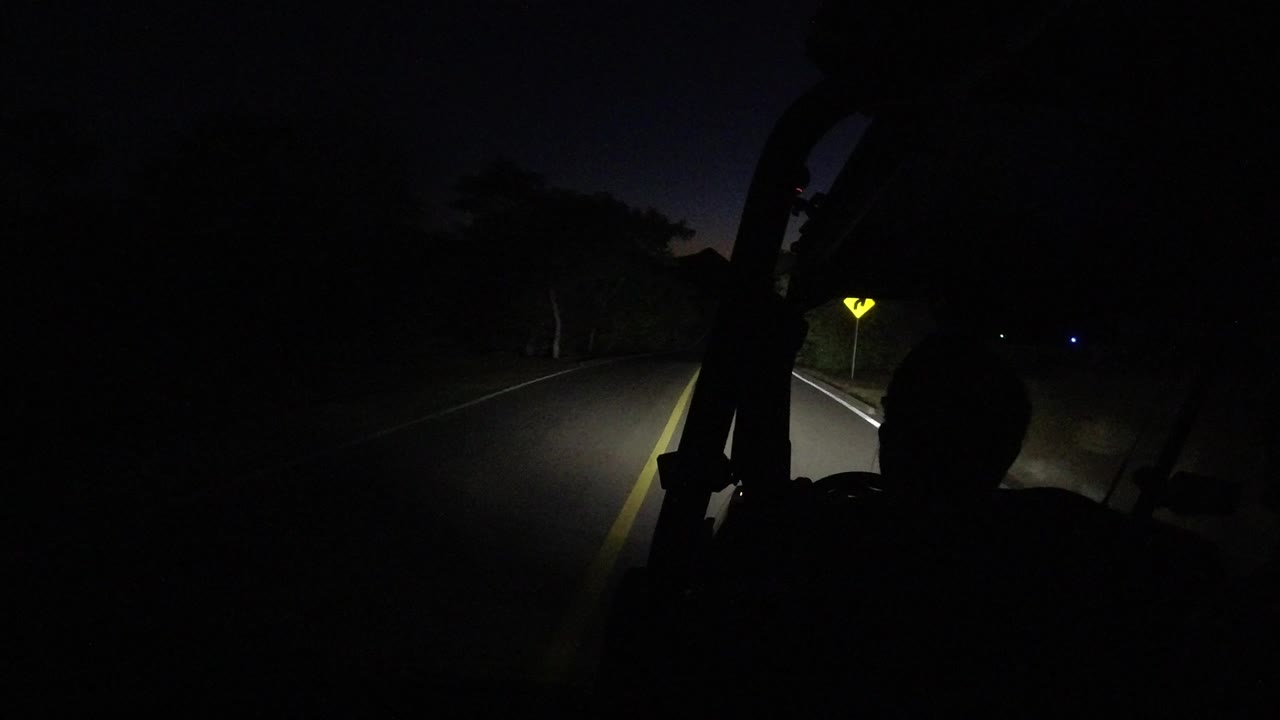 At 0:01 in Los Cabos, Mexico, the headlight beam reaches farther down the lane as a dark foreground silhouette remains centered.