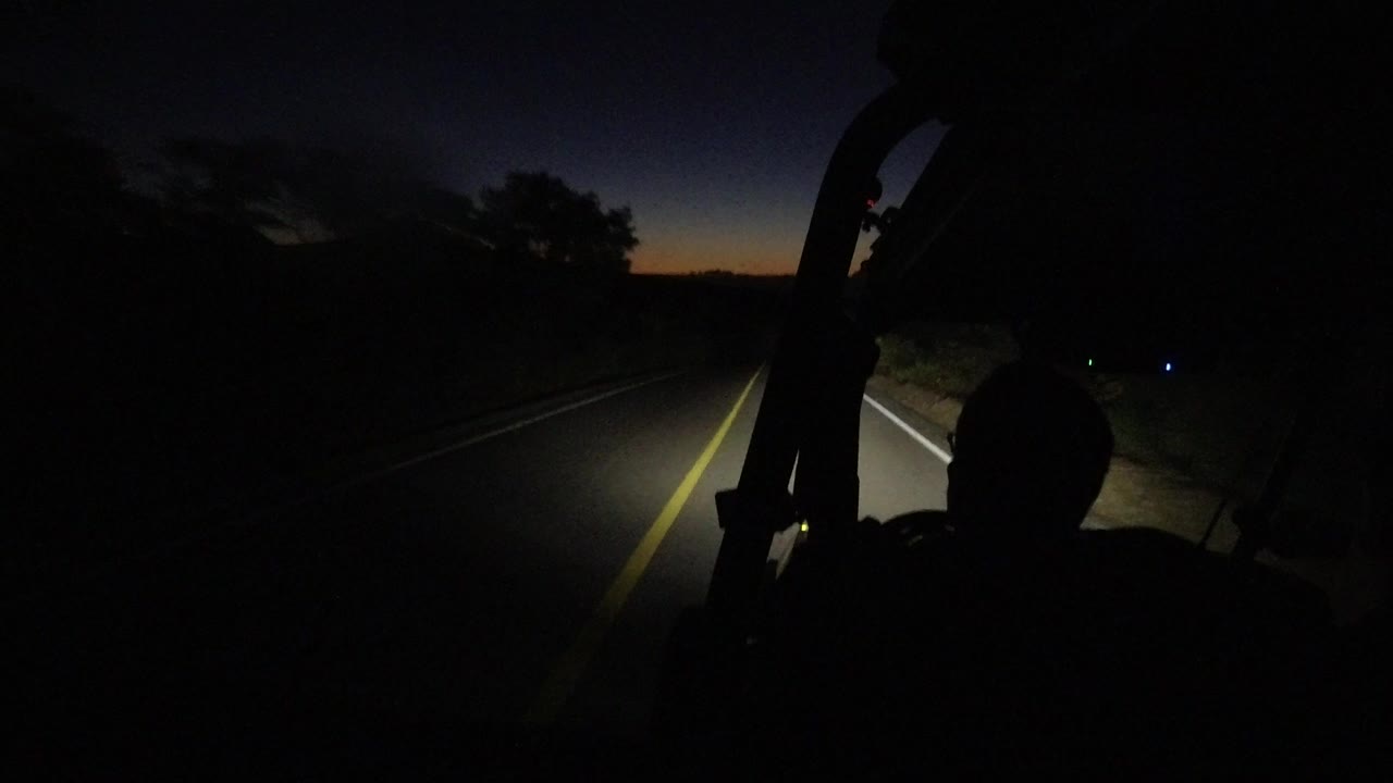 Dark road ahead from an open vehicle at dawn