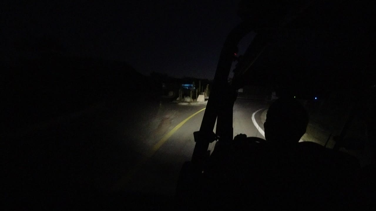 At 0:00 in Los Cabos, Mexico, a dark road curves ahead under Jeep headlights while a passenger silhouette and roll bar fill the foreground.