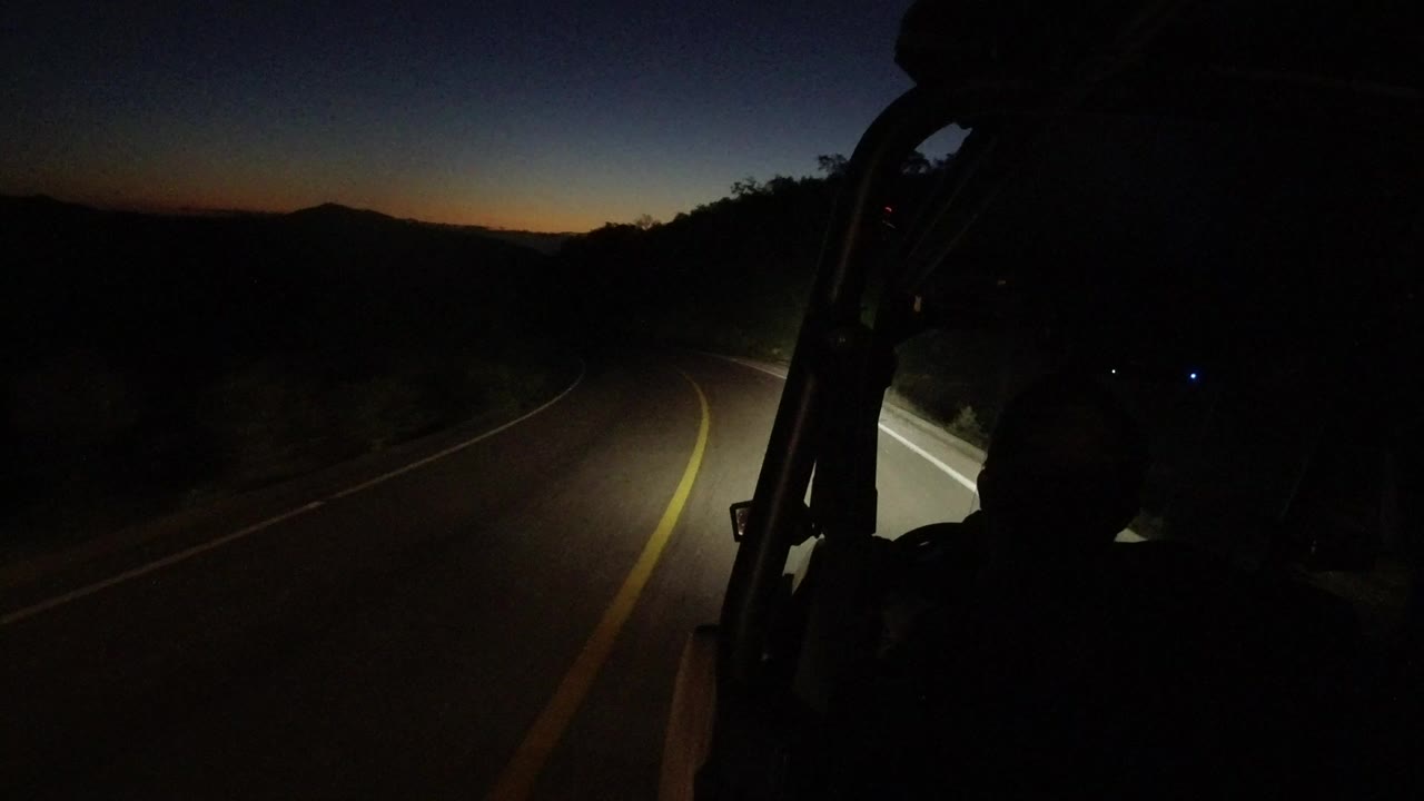 Dark road seen from inside a moving Wrangler at night.