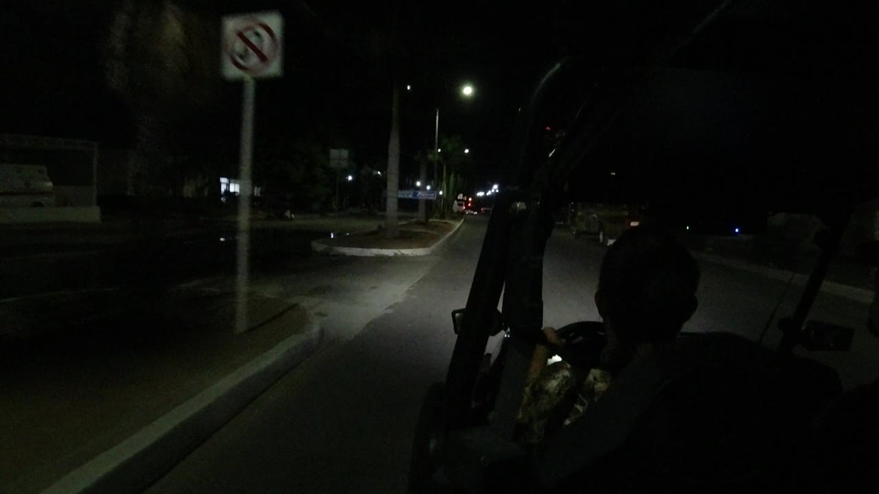 Night street with vehicle silhouette and roadside no-parking sign