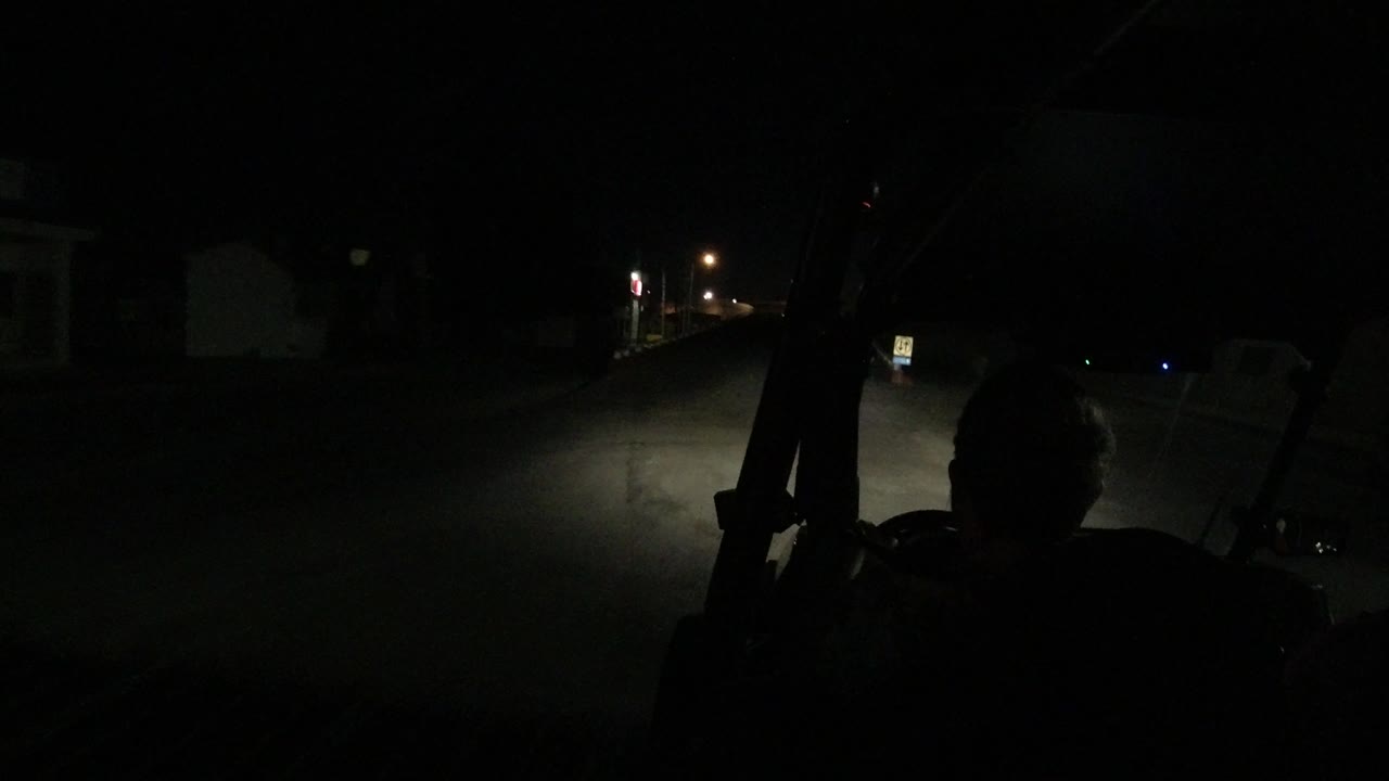 Dark road ahead from behind a driver silhouette.