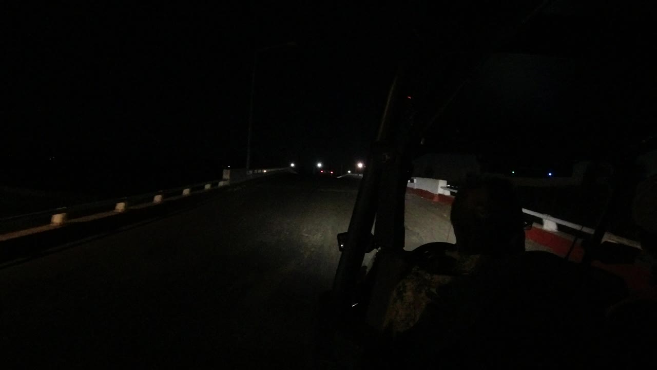 One second into the Los Cabos, Mexico drive, the driver's dark profile remains at right as the headlights reach farther down the empty road.