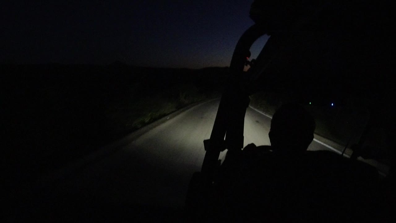 Dark road seen from inside a vehicle at night.