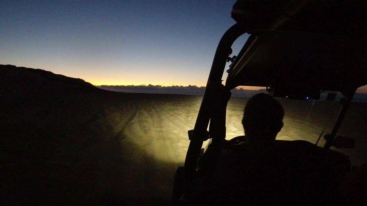 Silhouetted driver inside an off-road vehicle at dusk