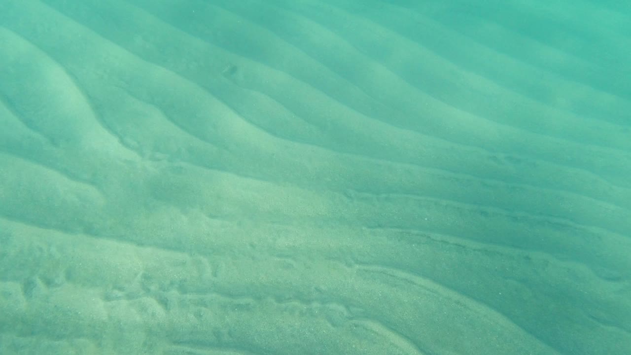 Turquoise water over rippled sandy bottom