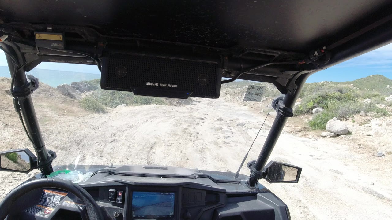 Off-road vehicle interior facing a rocky desert track