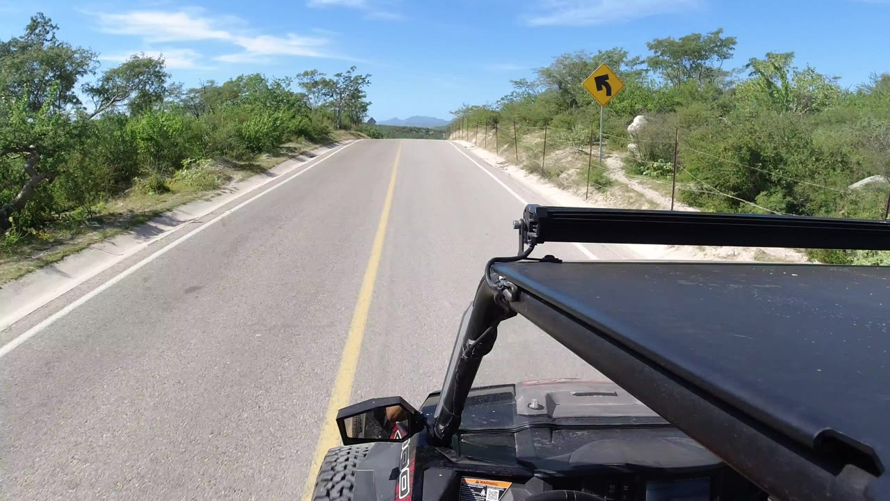 Two-lane road ahead with a black Wrangler hood in the foreground.