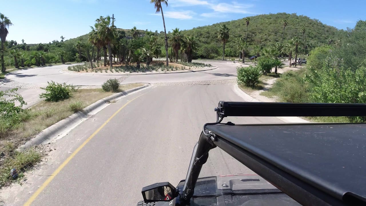 Jeep view entering a roundabout with palm landscaping