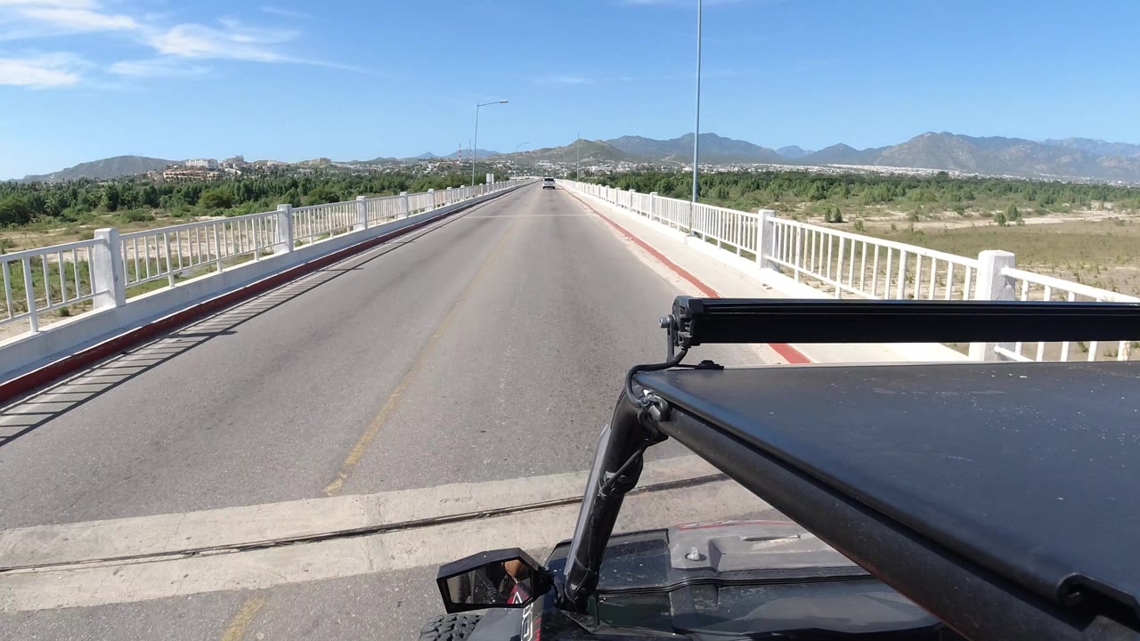Empty bridge lane stretches toward distant mountains.