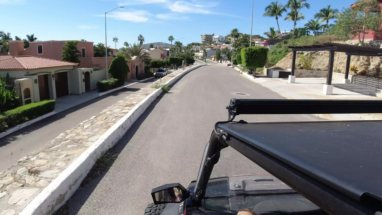 Forward view over a black Wrangler roof on a quiet residential street