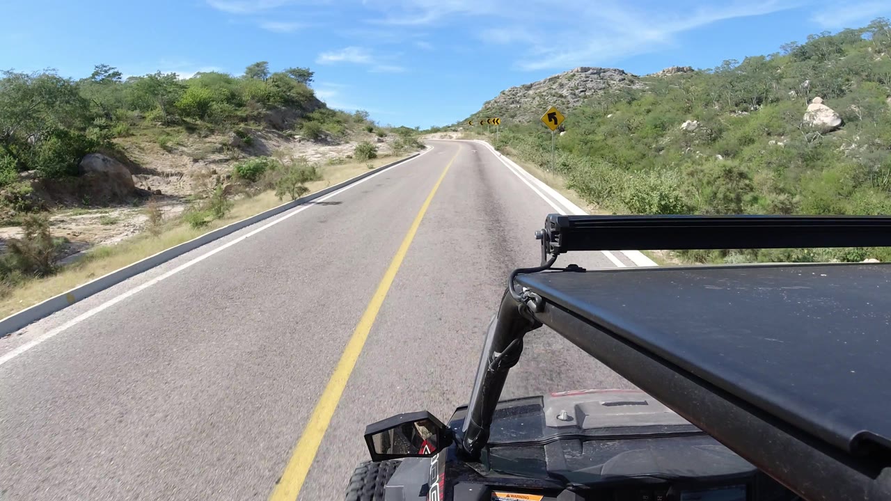 Straight empty road with curve sign visible ahead