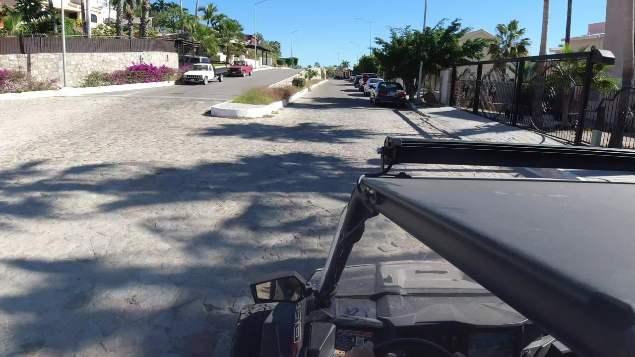 Wrangler hood on a residential street with parked cars and gated homes.