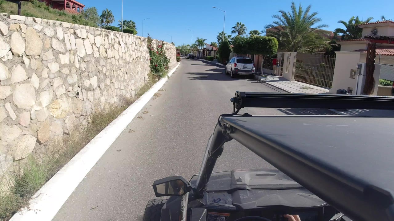 Wrangler hood facing a narrow residential road beside a stone wall.