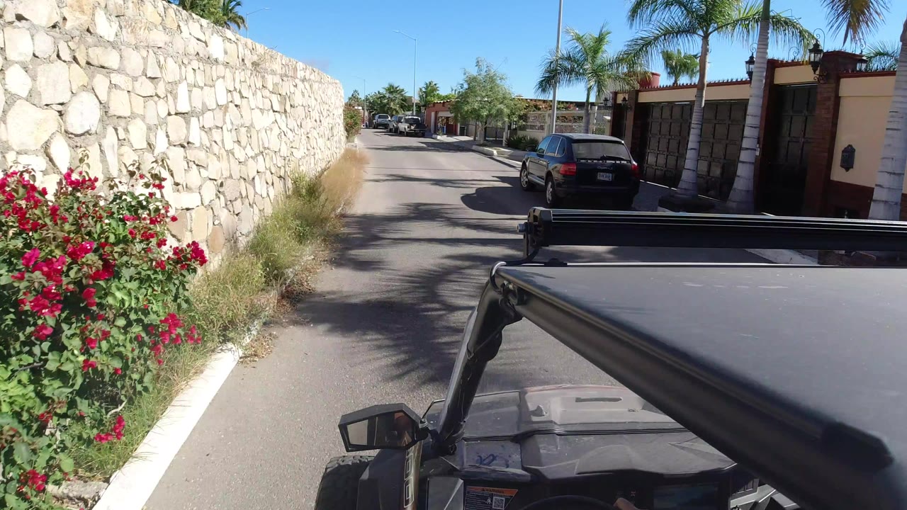 Jeep roof beside a stone wall on a sunny residential road